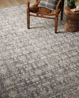 Elegant textured grey rug with wooden armchair.