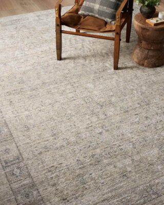 Wooden armchair on textured area rug in cozy interior.