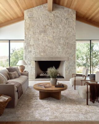 Modern living room with stone fireplace and wooden accents.