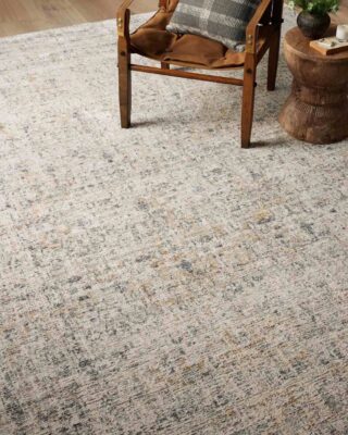 Wooden chair on textured area rug in cozy room.