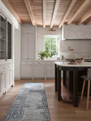 Modern kitchen with exposed wooden beams and white cabinetry.