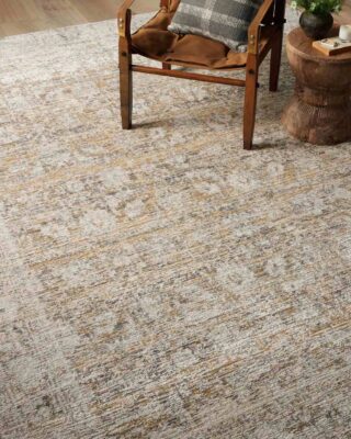 Cozy chair and decorative stool on textured area rug.