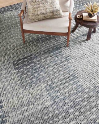 Modern living room with textured blue area rug and chair.