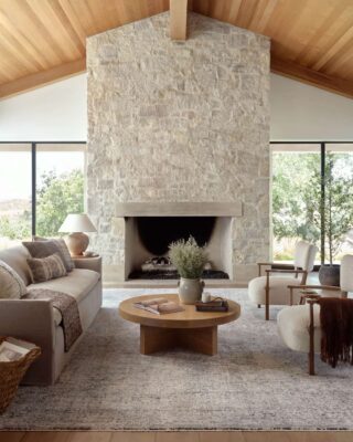 Elegant living room with stone fireplace and wooden ceiling.