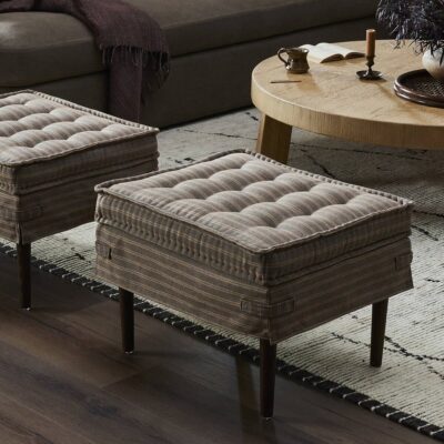 Two tufted storage ottomans in cozy living room setting. From the Amber Lewis x Four Hands Collection