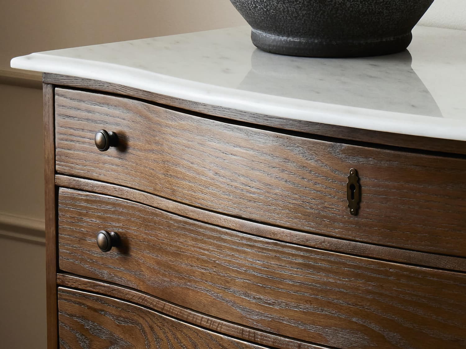 Close-up of wooden dresser with marble top.