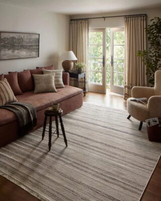 Cozy living room with sofa, chairs, and natural light.