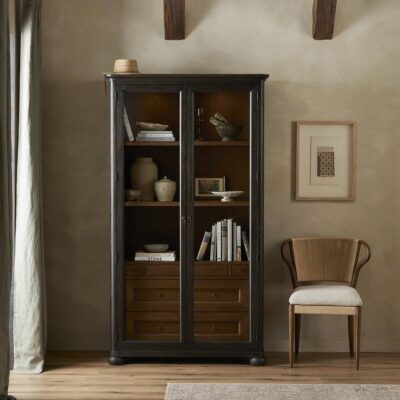 Elegant wooden cabinet with books and artifacts in study.